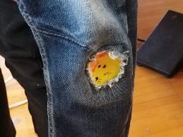 Ein kleiner gelber Fisch in der Jeans einer Person