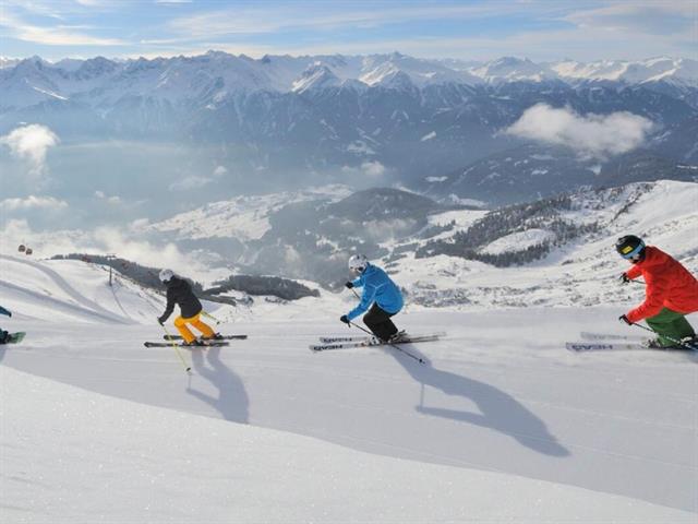 eine Gruppe von Menschen, die auf einem Berg Ski fahren